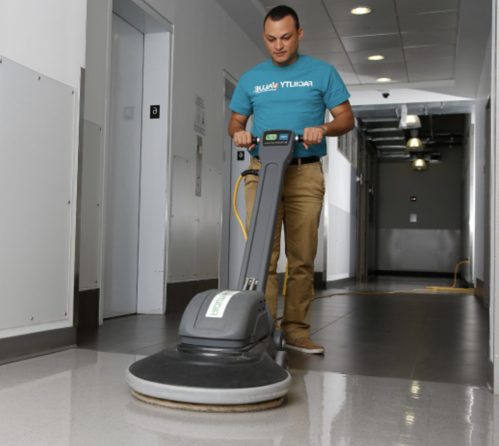 Technician buffing a hallway floor